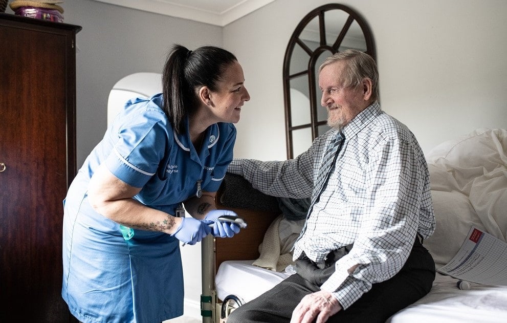 Community nurse, Danni, leaning towards a patient