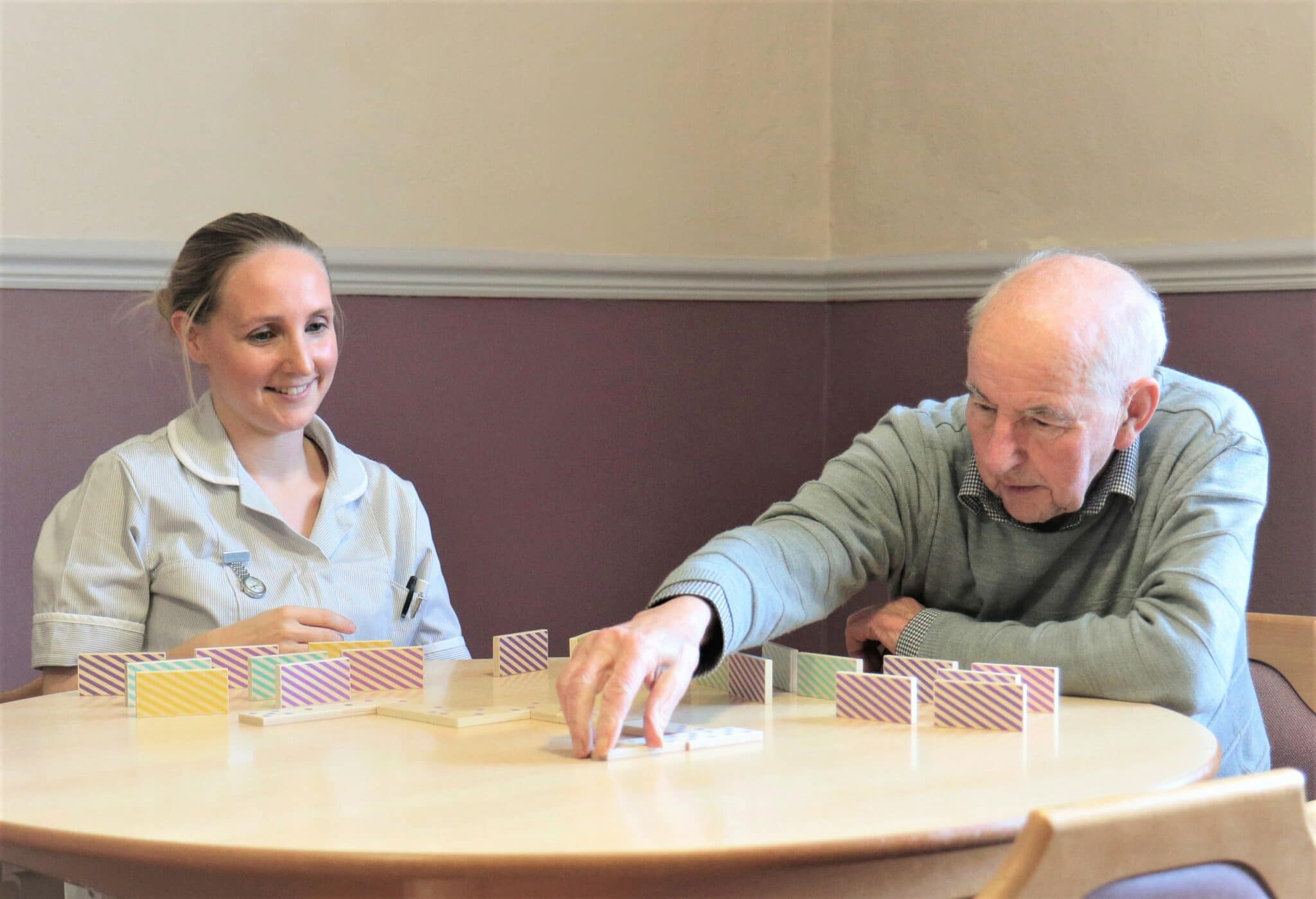 elderly man playing a game with a carer