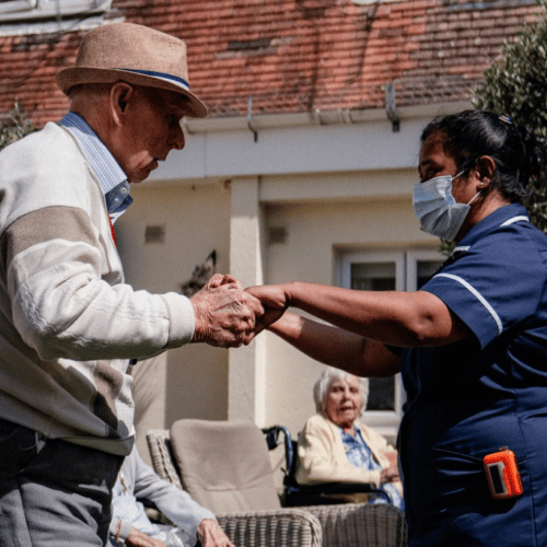 Older man and carer dancing