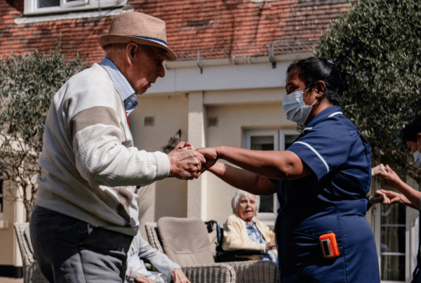 Older man and carer dancing