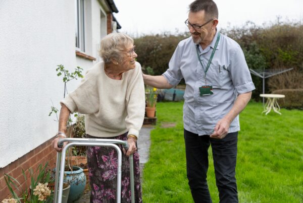 Lady with zimmer frame in garden with reablement worker