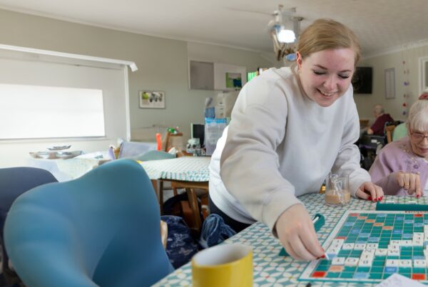 Care worker and older lady playing scrabble