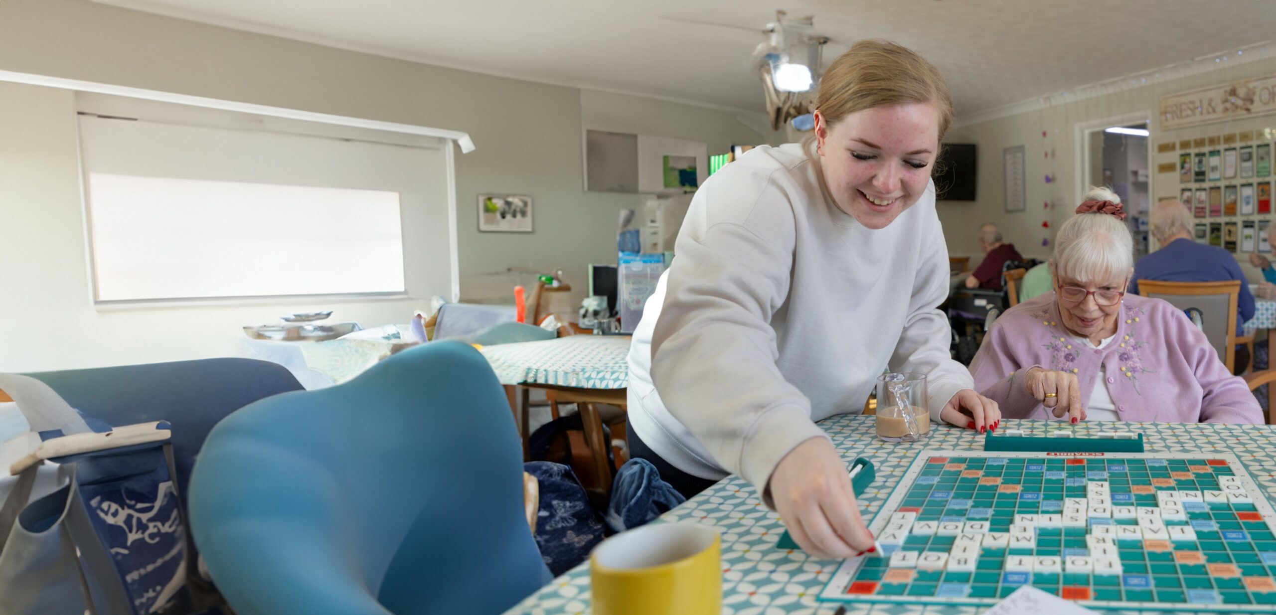 Care worker and older lady playing scrabble
