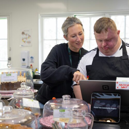 Two people working on a till at a cafe