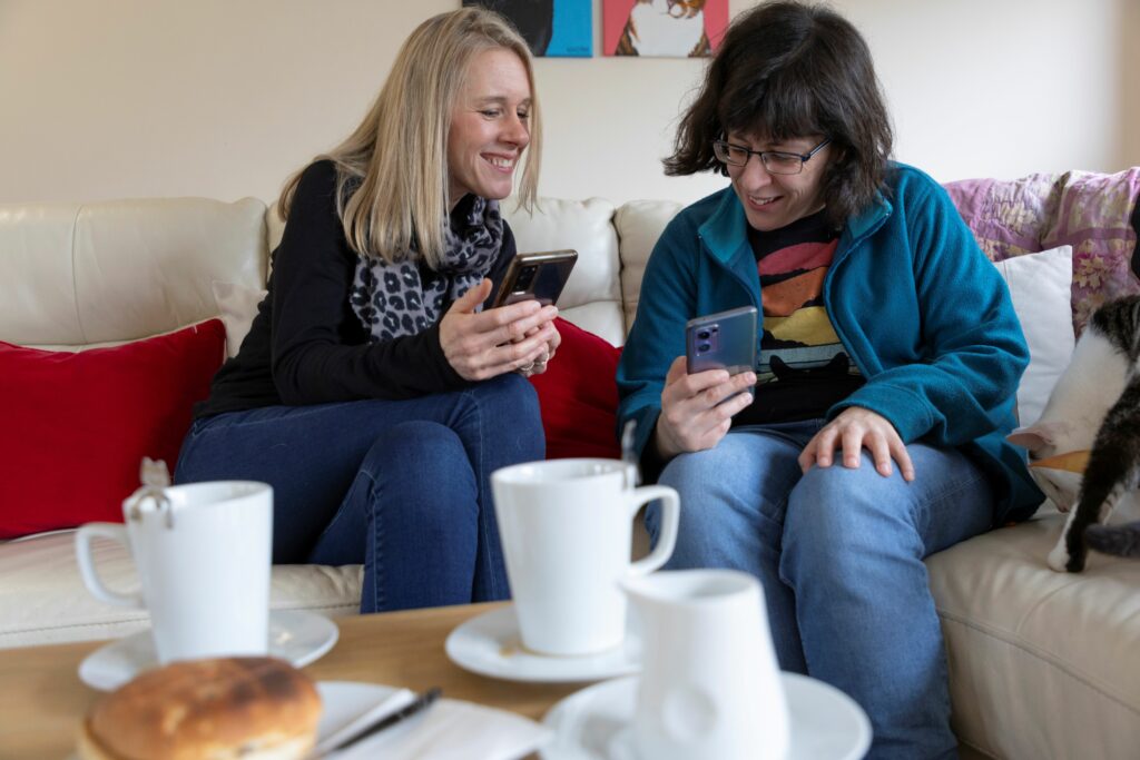 Two people looking at phones at a cafe