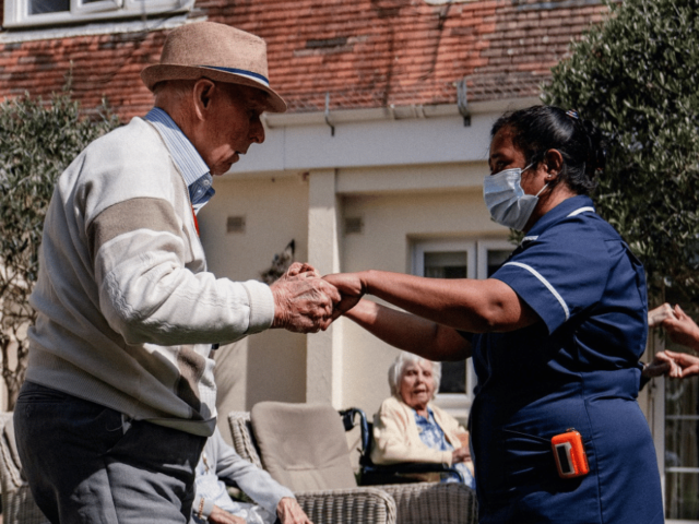 Older man and carer dancing