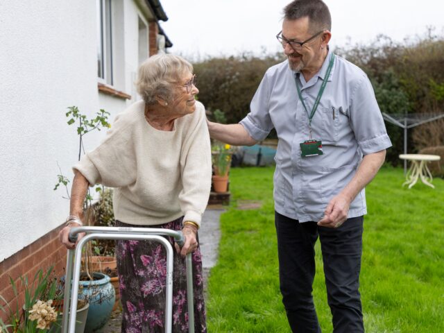 Lady with zimmer frame in garden with reablement worker