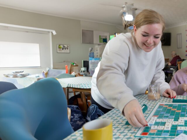 Care worker and older lady playing scrabble