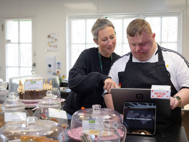 Two people working on a till at a cafe