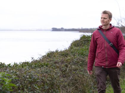 A man walking along the coast