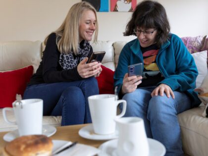 Two people looking at phones at a cafe