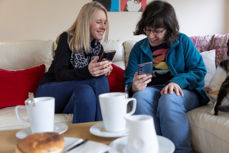 Two people looking at phones at a cafe