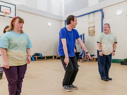 Three people doing exercise in a sports hall